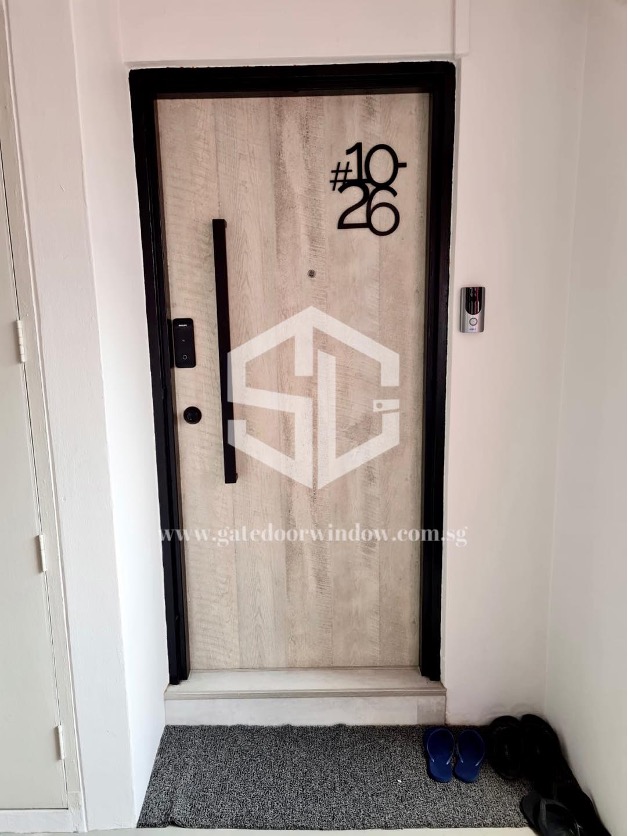 wooden front door with a dark metal gate featuring a quirky, stylized unit number 